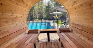 Una terrassa de fusta amb piscina i mobiliari exterior.