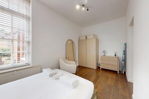A bedroom with a bed, a wardrobe, a dresser, and a mirror. - Amazing 1BR Flat w/ Communal Garden and Parking (London)