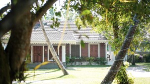 A house with a tiled roof, wooden doors, and a small porch. - Kochi Riverside Homestay (Kanayannur)