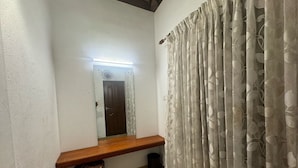 A bathroom with a wooden bench, a mirror, a door, and a curtain. - Kochi Riverside Homestay (Kanayannur)