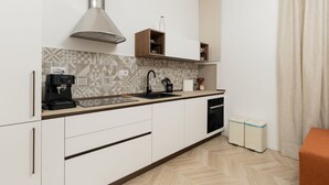 Una cocina moderna con estufa integrada, máquina de café y campana extractora de acero inoxidable.
