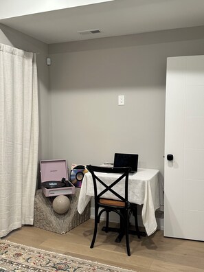 A room with a table, a chair, a laptop, a record player, and a door. - Modern South Philly Townhome. Rooftop. Skyline Views. Home Office.  Gym (Philadelphia)