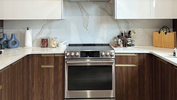 A kitchen with wooden cabinets, a stainless steel stove, and marble backsplash. - Modern South Philly Townhome. Rooftop. Skyline Views. Home Office.  Gym (Philadelphia)