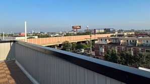 A view from a balcony overlooking a cityscape with a bridge, buildings, and a clear sky. - Modern South Philly Townhome. Rooftop. Skyline Views. Home Office.  Gym (Philadelphia)