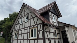 Ein traditionelles Fachwerkhäuschen mit steilem Dach, vielen Fenstern und der Hausnummer 12 auf der Fassade.