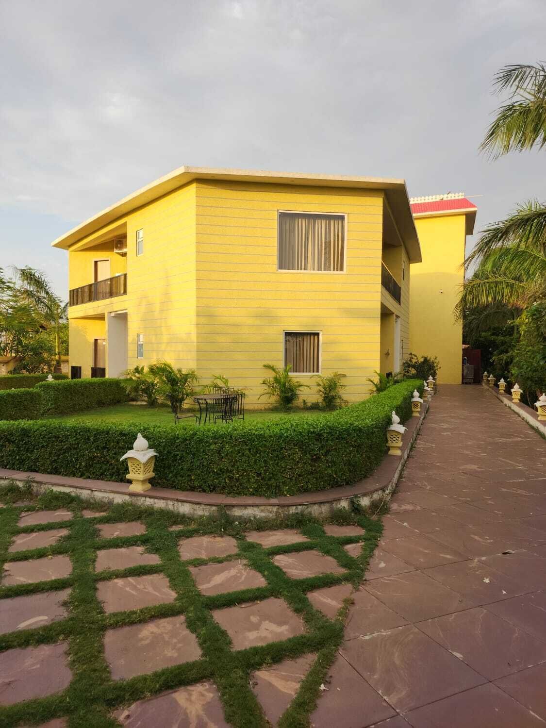 A two-story building with a flat roof and a balcony on the upper floor.