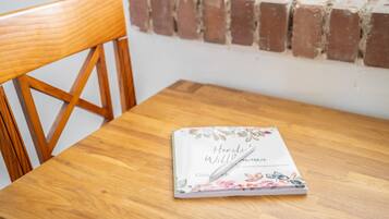 A wooden table with a book titled 'Herli Williuren' and a pen on it.