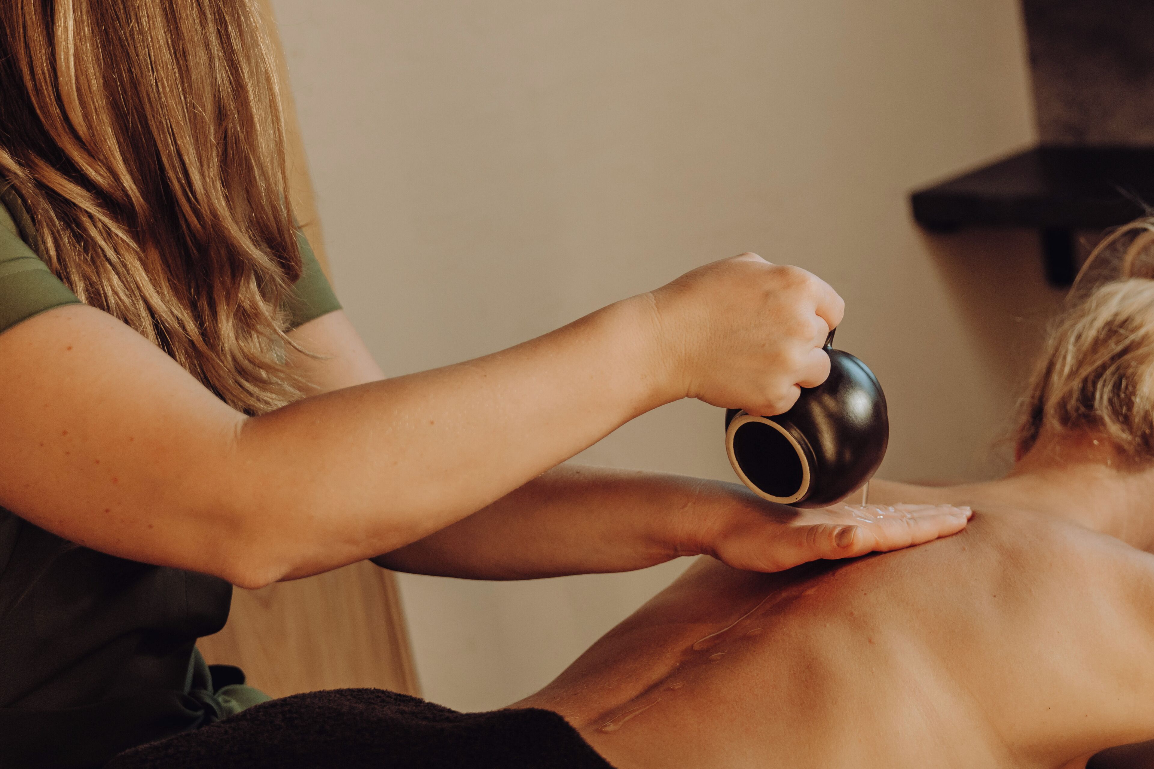 En person modtager massage med en oliepose.