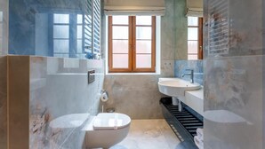 A bathroom with a toilet, sink, and window.