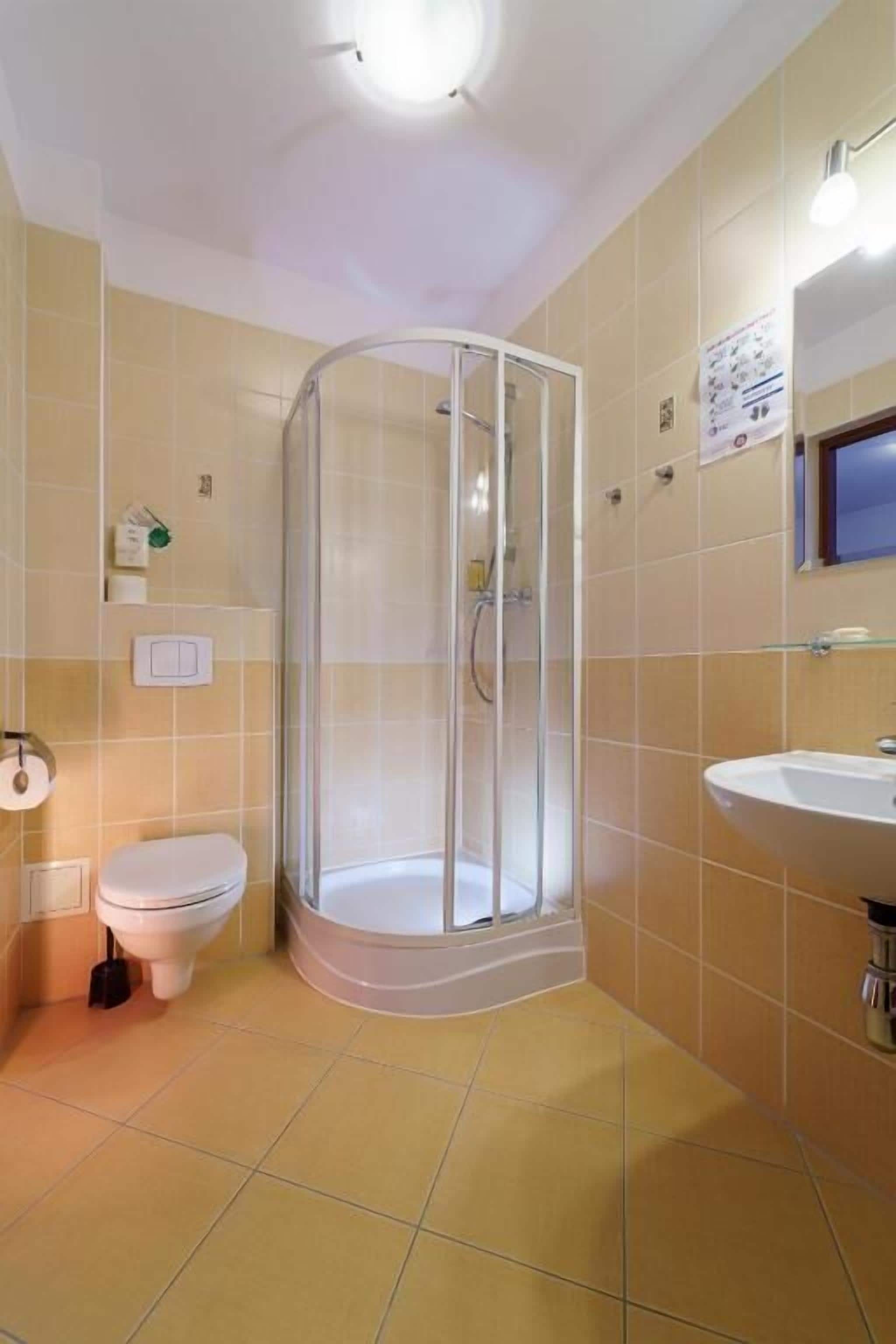 A bathroom with a shower, toilet, and sink.