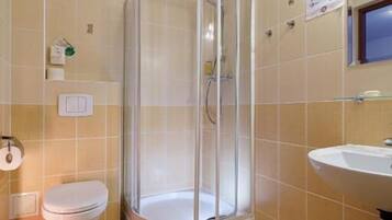 A bathroom with a shower, toilet, and sink.