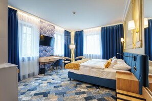 A hotel room with a bed, desk, chair, and a TV. - Le Mont Medical & Spa (Świeradów-Zdrój)