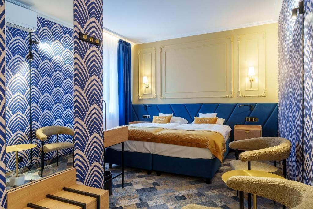 A hotel room with a large bed, a desk, and a chair.