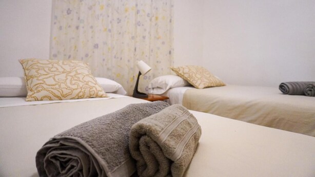A hotel room with two beds, each with a pillow and a rolled towel. - Holiday house Casa Argelio (Vallehermoso)