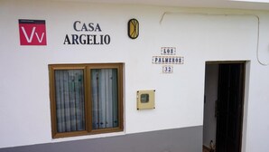 A building with a sign reading 'CASA ARGELIO' and a smaller sign indicating 'LOS PALMEROS 32'. - Holiday house Casa Argelio (Vallehermoso)