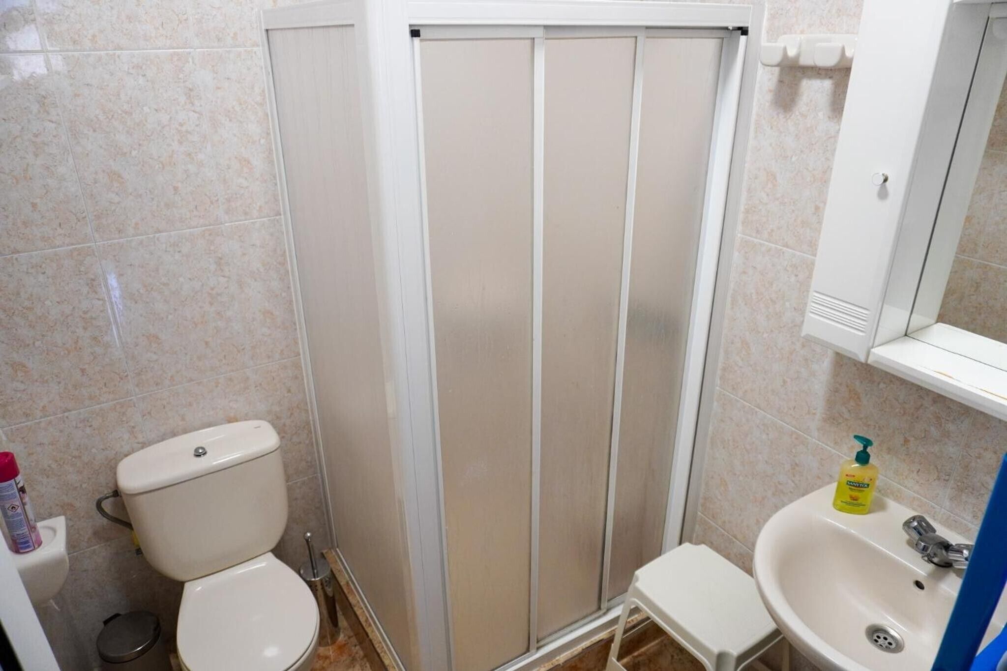 Une salle de bain comprenant des toilettes, un lavabo et une douche.