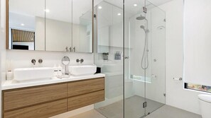 A modern bathroom with a double sink vanity, a glass shower enclosure, and a large mirror. - Eden at Kiama, penthouse apartment within Kove Apartments centrally located. (Kiama)