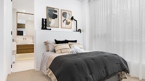 A bedroom with a bed, a bedside table, a mirror, and a window with curtains. - Eden at Kiama, penthouse apartment within Kove Apartments centrally located. (Kiama)