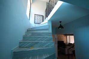 A staircase with a metal railing leading to a landing.