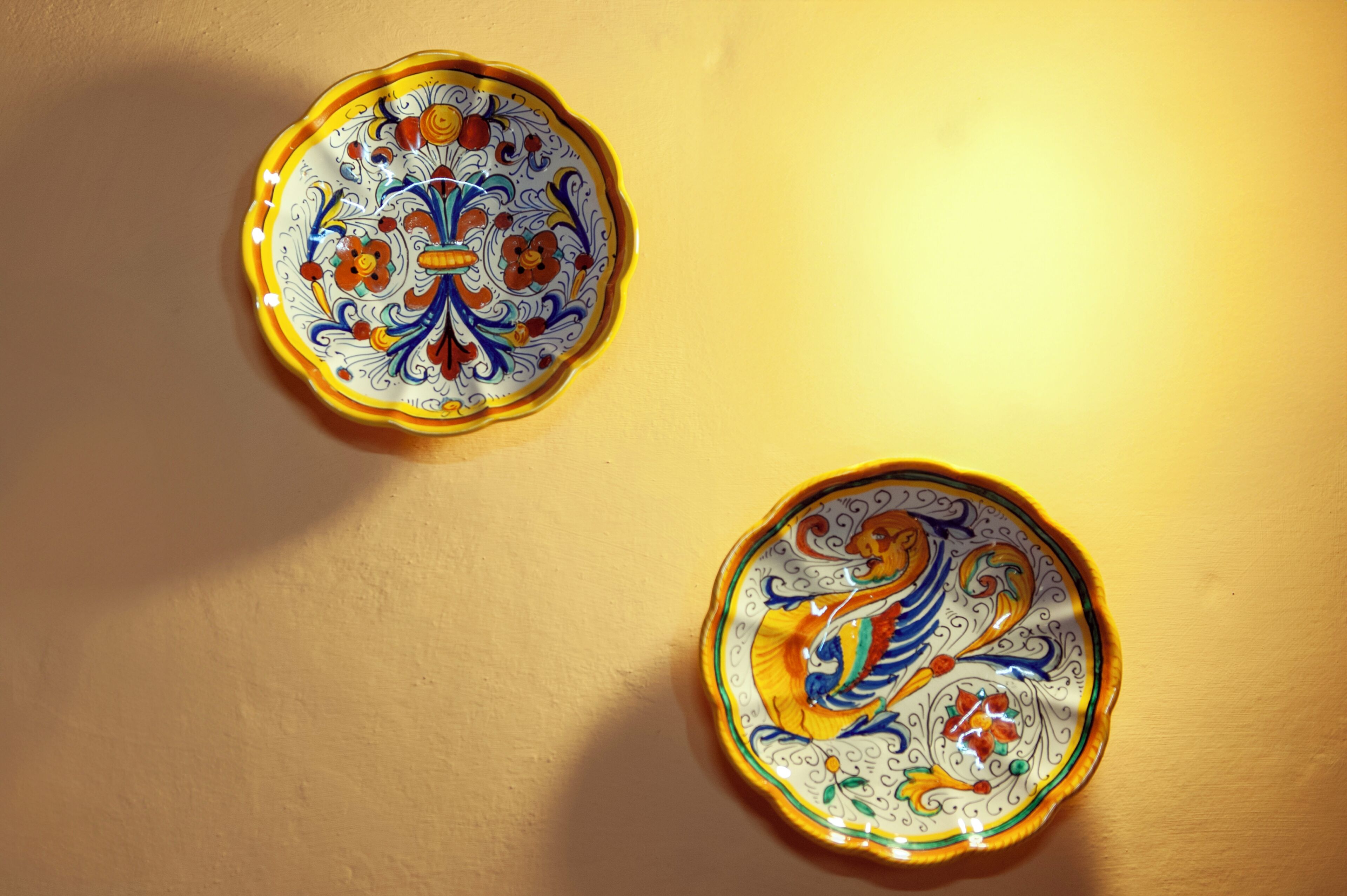 Two ceramic plates with intricate designs, placed on a plain surface.