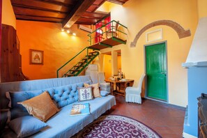 Uma sala de estar aconchegante com um sofá azul, uma escada verde e uma porta verde.