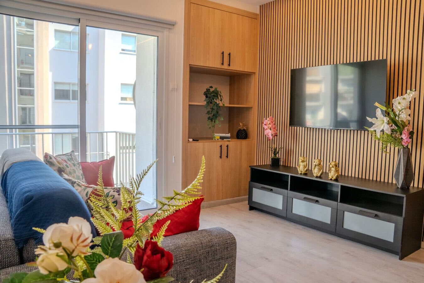 Un salon moderne avec un canapé, un téléviseur et un meuble en bois.