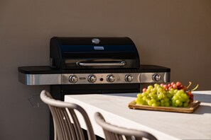 A black grill with four control knobs and a brand name visible. - Villa Idola Dassia Corfu (Corfu)