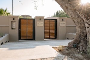 Uma entrada com portão e duas placas com os dizeres 'IRYDA' e 'IDOLA' para as Villas Black & White.