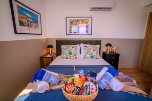 A hotel room with a bed, two nightstands, a wall-mounted air conditioner, and a framed picture above the bed. - 4.97 Super Host`s New Boutique & Prime Location (Limassol)