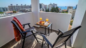 A balcony with two chairs, a table with a tray of food and drinks, and a city view. - 4.97 Super Host`s New Boutique & Prime Location (Limassol)