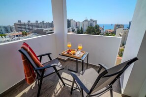 A balcony with two chairs, a table with a tray of food and drinks, and a city view. - 4.97 Super Host`s New Boutique & Prime Location (Limassol)