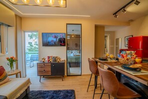 A modern kitchen with a dining area, a large window, and a red refrigerator. - 4.97 Super Host`s New Boutique & Prime Location (Limassol)