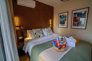 A hotel room with a bed, pillows, a wall-mounted air conditioner, and two framed pictures. - 4.97 Super Host`s New Boutique & Prime Location (Limassol)