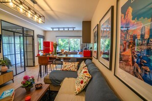 Een moderne woonkamer met een bank, een eethoek en een keuken.
