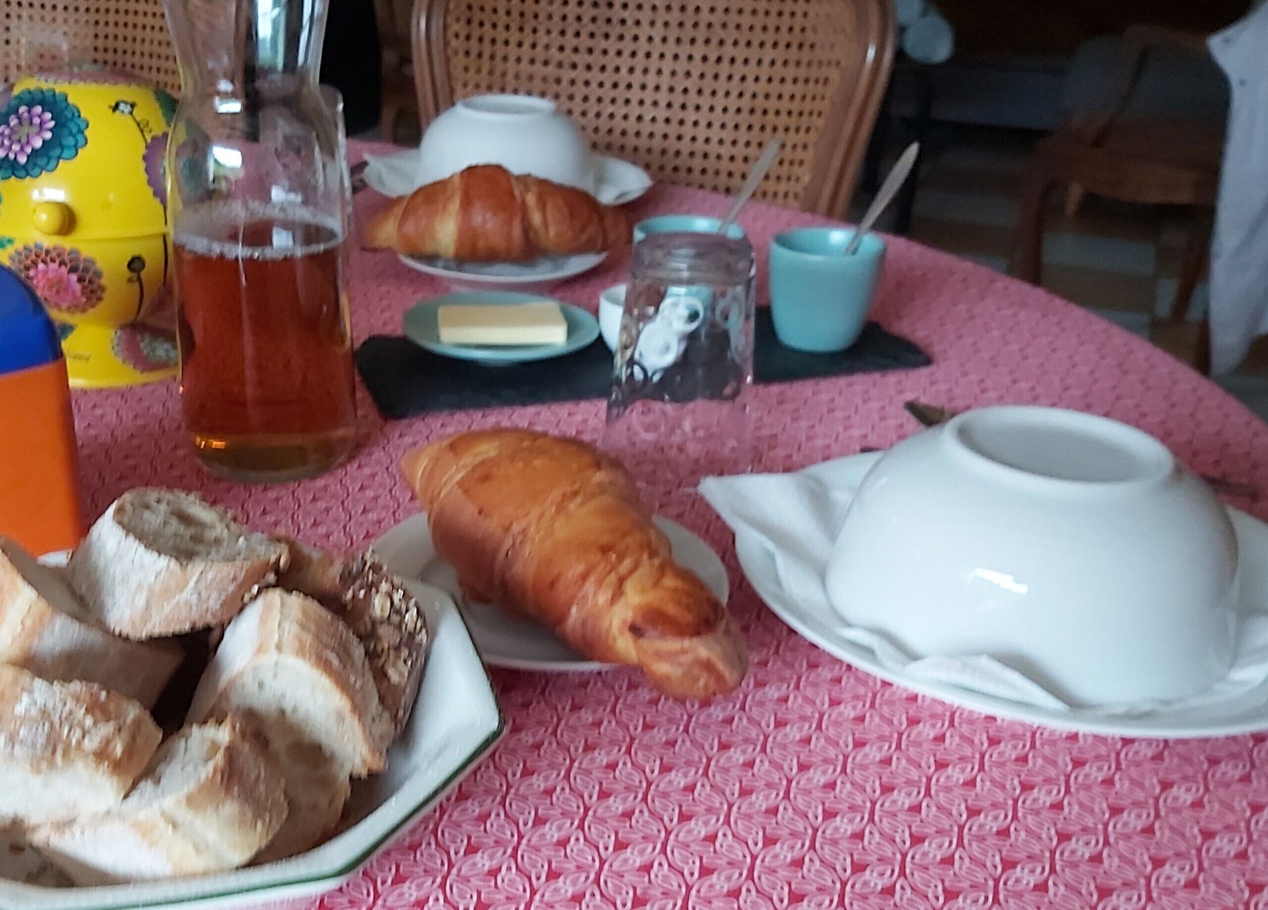 A table with food items, a teapot, and a cup.