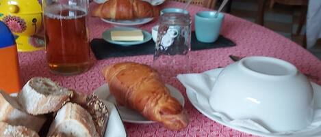 A table with food items, a teapot, and a cup.