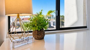 A room with a window, a lamp, a potted plant, and a motivational sign.