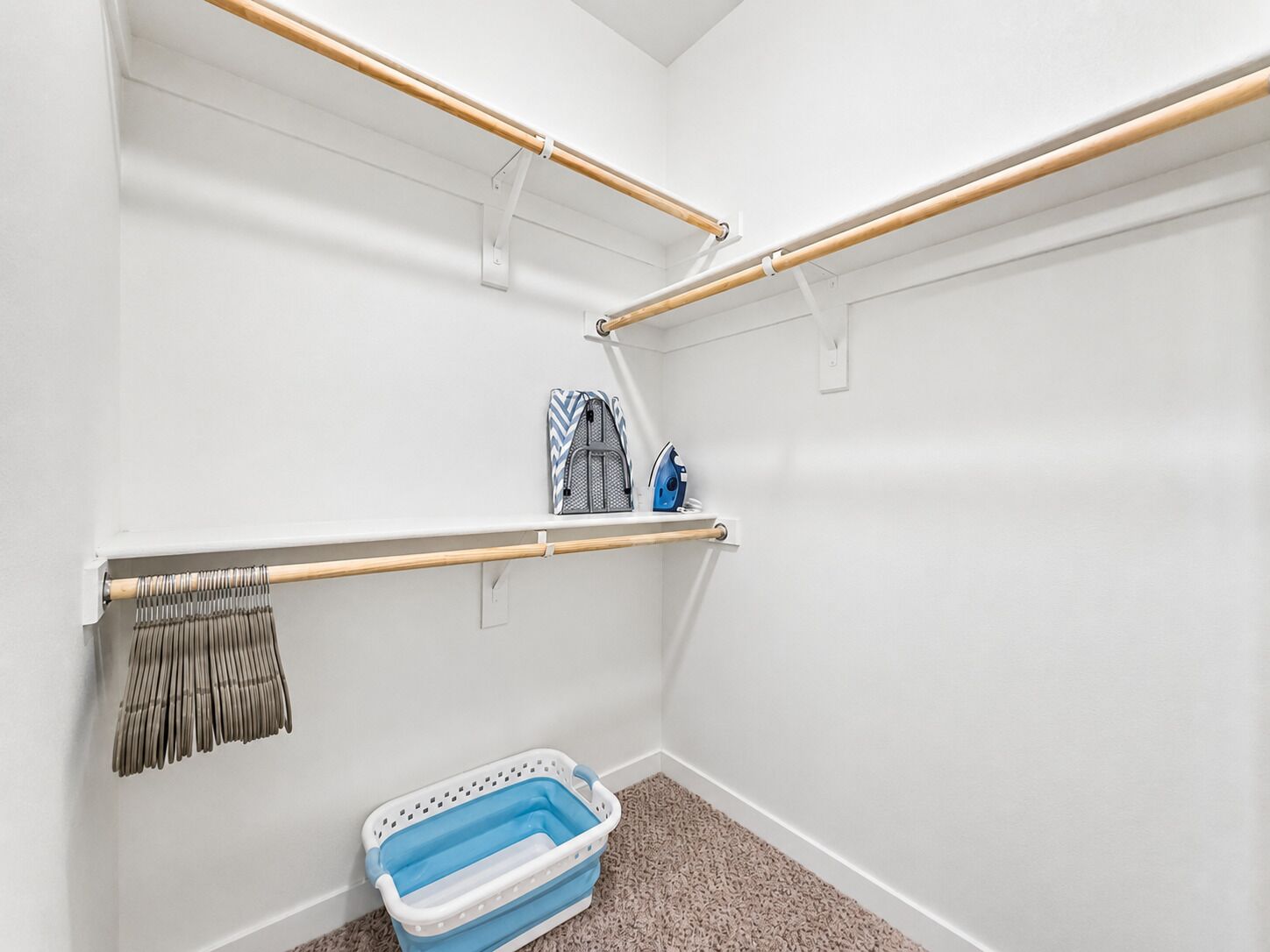 Un placard de rangement avec des étagères, une tringle à vêtements et un panier à linge.