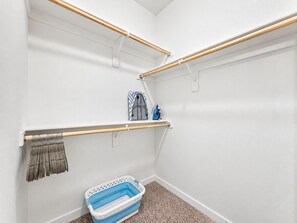 A storage closet with shelves, a hanging rack, and a laundry basket. - Cays Luxury Living! Resort Pool, Gym, Walk to Restaurants (Chandler)