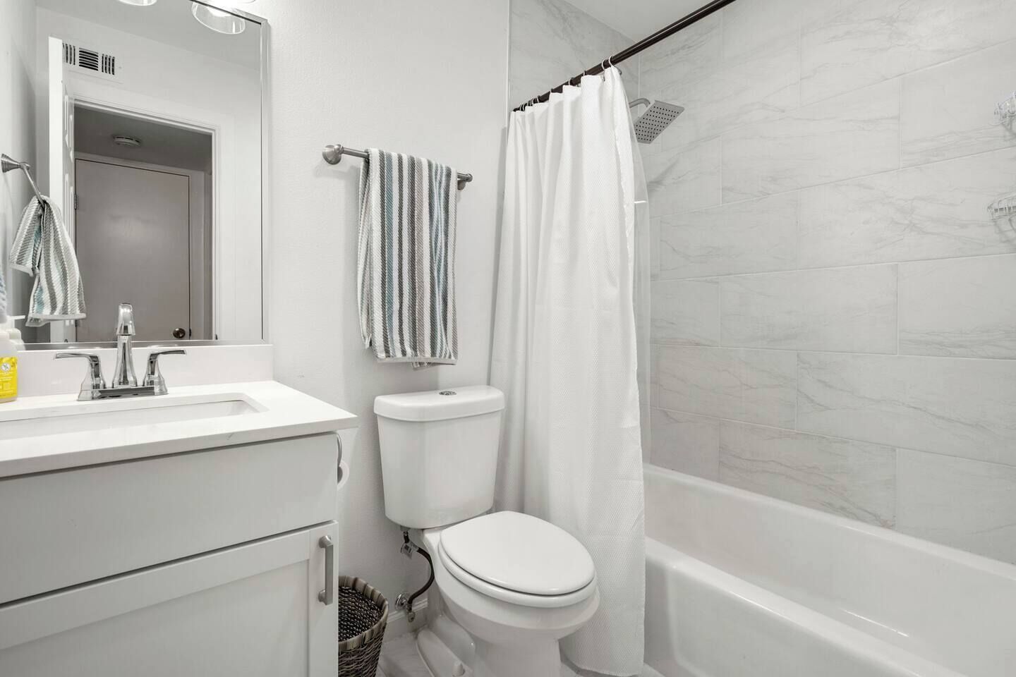 Ein modernes Badezimmer mit Toilette, Waschbecken und Duschbereich.