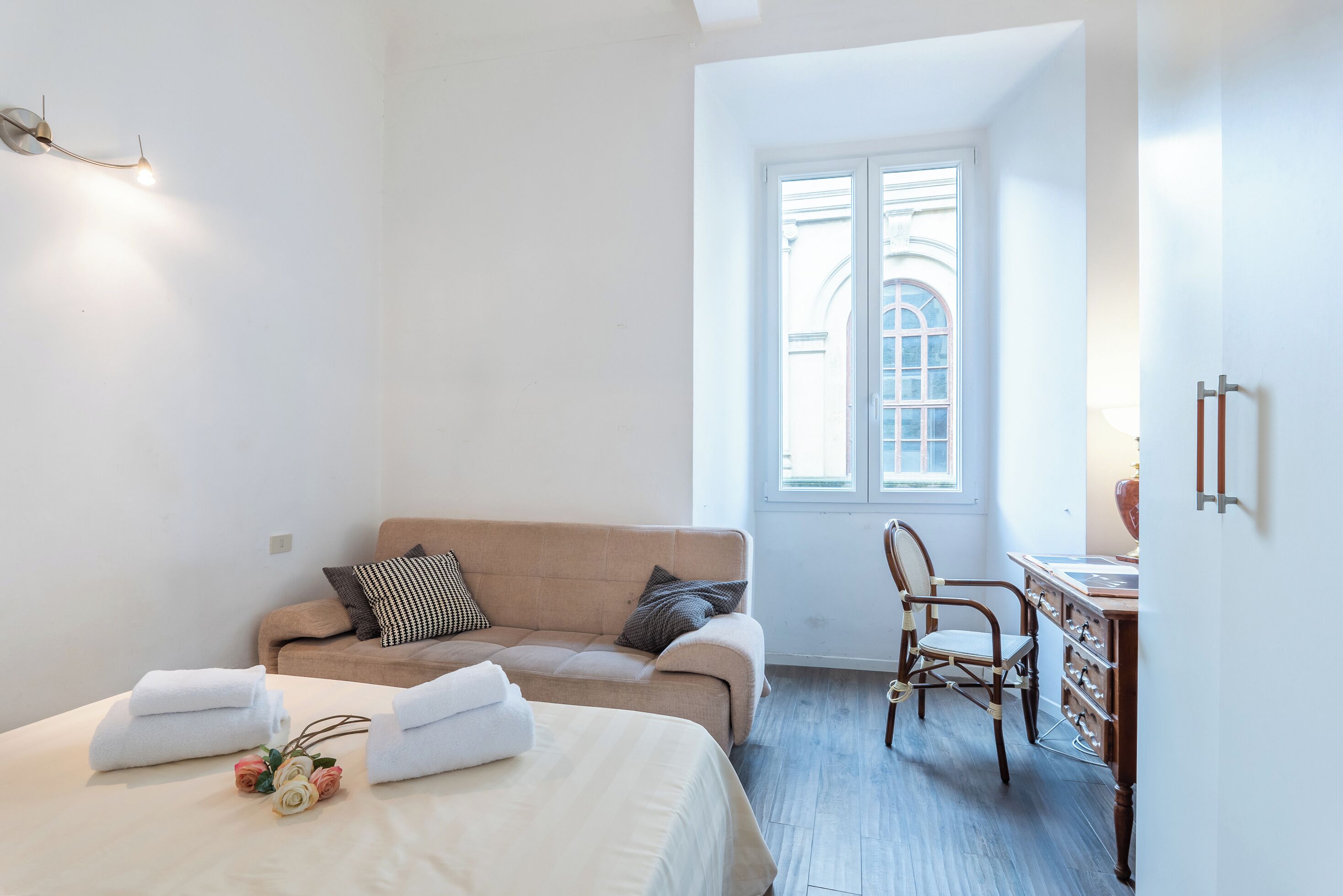 Une chambre à coucher avec un lit, un canapé, une chaise, un bureau et une fenêtre.