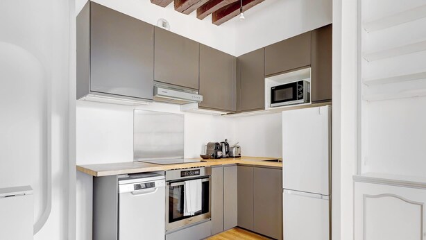 A compact kitchen with a built-in oven, microwave, and dishwasher. - BM – Élégance Parisienne & Vue sur Saint-Merri (Paris)