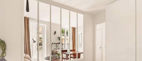A modern room with a large window, a bed, a desk, and a chair.