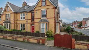 A two-story residential building with a red door, bay windows, and a brick facade. - Glendale House Two Bedroom Apt By Guestz (Lytham St Annes)