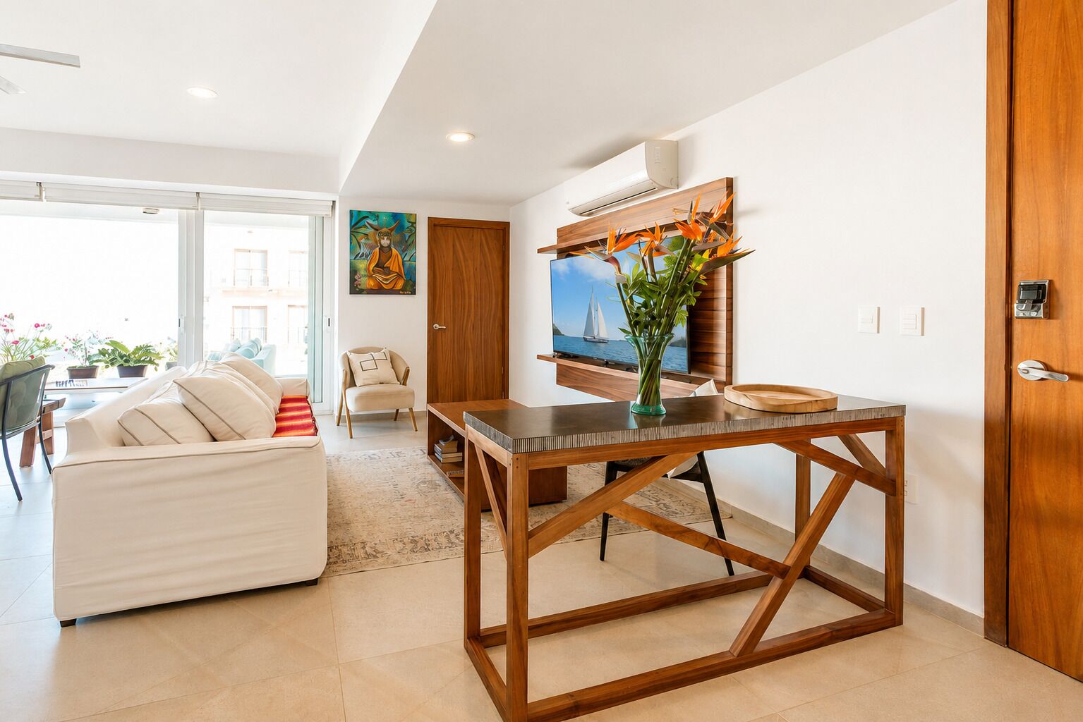 Een moderne woonkamer met een bank, een houten eettafel en een schilderij aan de muur.