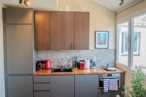 Eine moderne Küche mit Backofen, Spüle und einem Fenster für natürliches Licht.