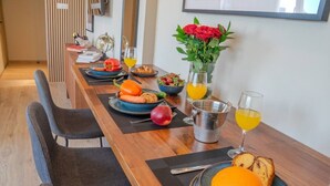 Et spisebord med tallerkener med mad, glas med appelsinjuice og en vase med blomster.