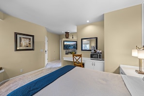 A hotel room with a bed, a desk with a computer, a television, and a microwave. - Mt Bachelor Village 332 | Hot tub | River Views (Bend)