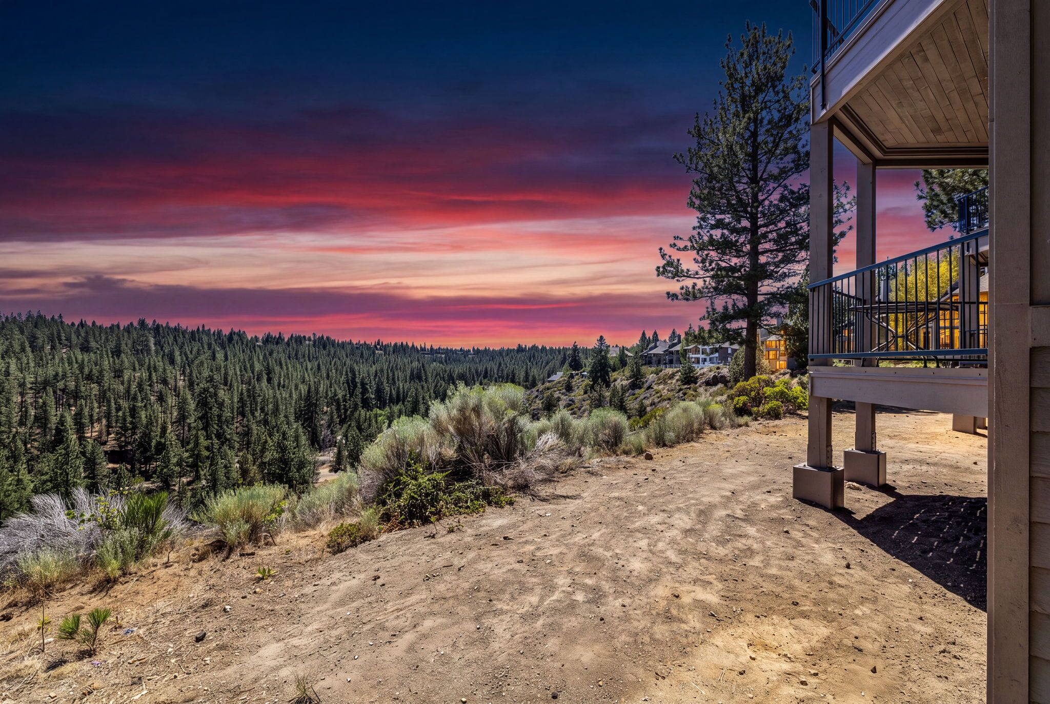 A building with a view of a forest and a sunset.