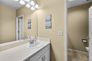 A bathroom with a white sink, a mirror, and three wall-mounted light fixtures. - Mt Bachelor Village 332 | Unit B | Private Suite (Bend)